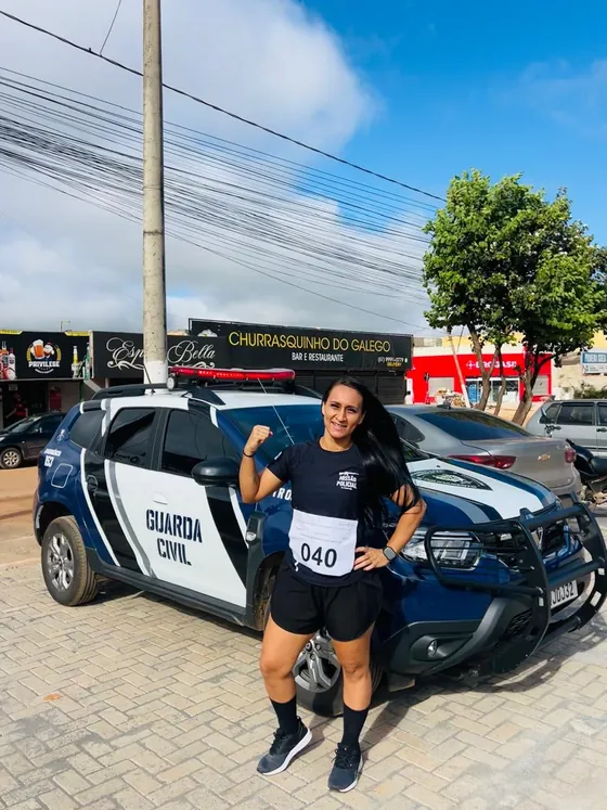 Aluna aprovada em frente à viatura da Guarda Civil